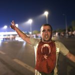 A man covered with blood points at the Bosphorus bridge as Turkish military clashes with people at the entrance to the bridge in Istanbul on July 16, 2016. 
Turkish military forces on July 16 opened fire on crowds gathered in Istanbul following a coup attempt, causing casualties, an AFP photographer said. The soldiers opened fire on grounds around the first bridge across the Bosphorus dividing Europe and Asia, said the photographer, who saw wounded people being taken to ambulances.

 / AFP / Bulent KILIC        (Photo credit should read BULENT KILIC/AFP/Getty Images)